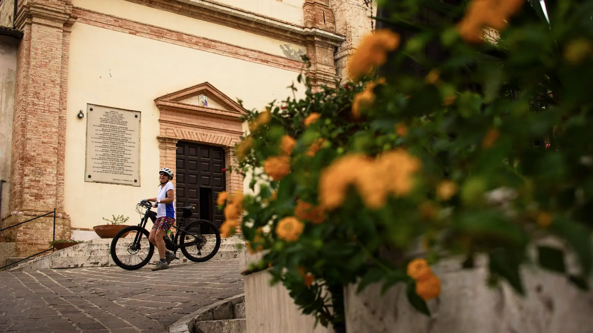 Cyclist with e-bike exploring a historic village in Abruzzo, Italy