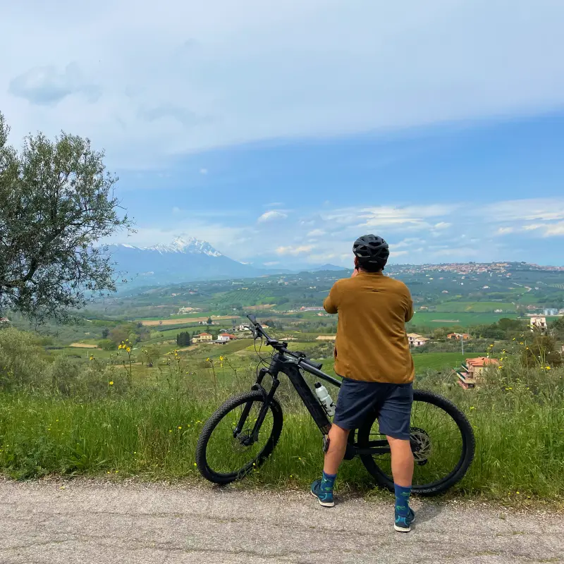 Cyclist enjoying the panoramic views over the Abruzzo hills and the Gran Sasso mountains during the e-bike tour