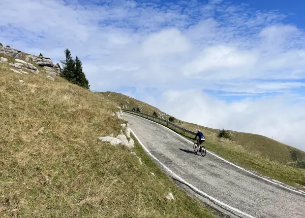Cyclist climbing the scenic road to Monte Grappa during a Veneto Bike Tour