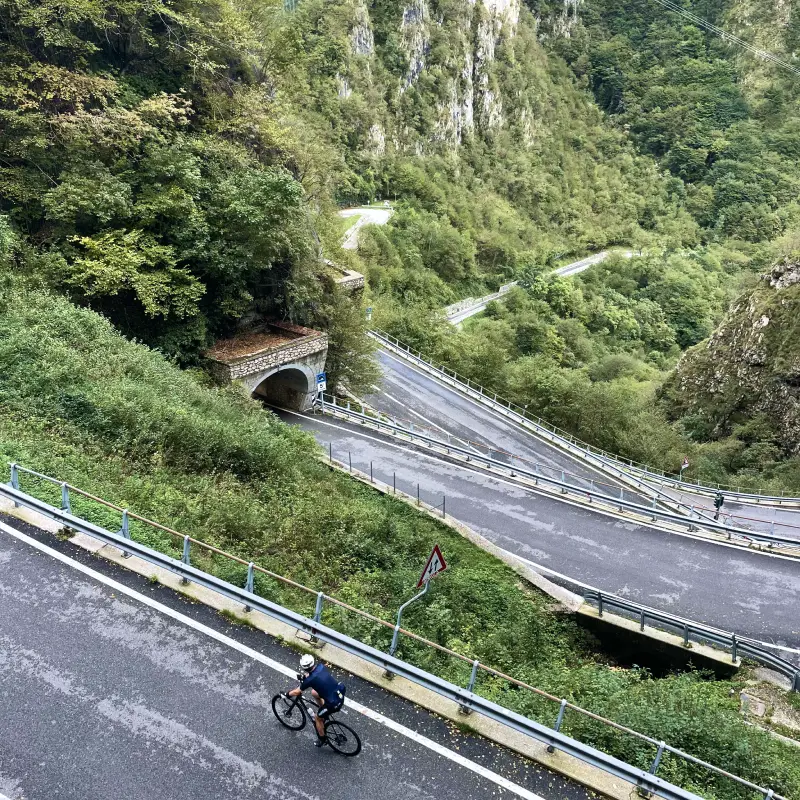 Cyclist riding through the tunnels and switchbacks of San Boldo Pass