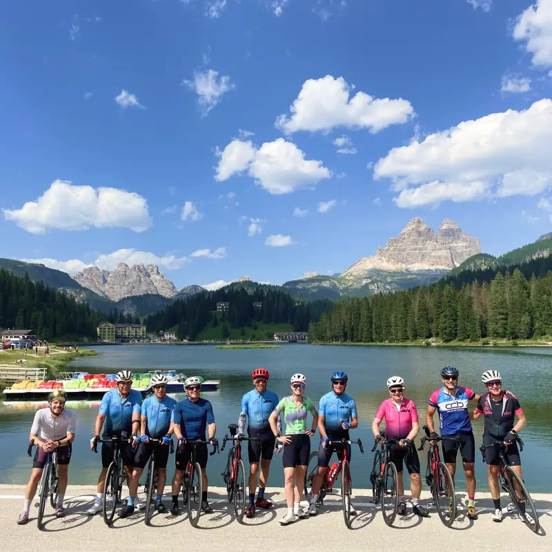 Group of cyclists at Lake Misurina with the Tre Cime di Lavaredo in the distance