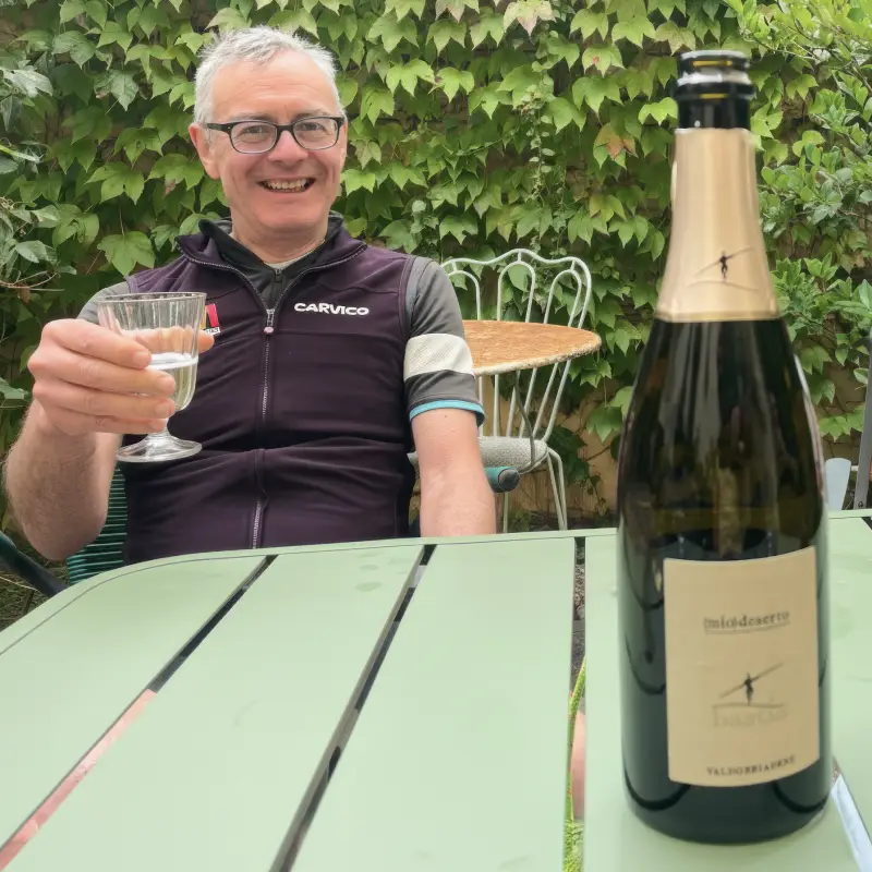 Cyclist toasting with a glass of Prosecco at the end of the tour