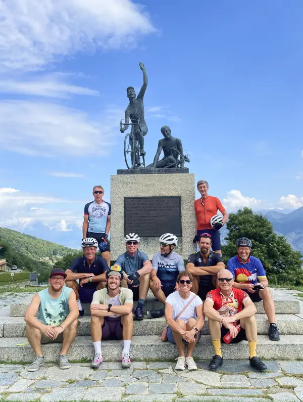 Cyclists posing at the Madonna del Ghisallo monument near the Cycling Museum on the Stelvio to Lake Como Bike Tour