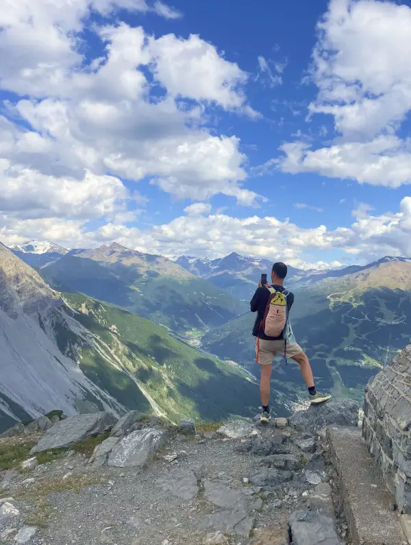 Hiker enjoying the panoramic view from Monte Scale above Bormio during the E-bike the Alps tour