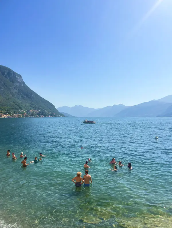 Riders and locals cooling off in the clear waters of Lake Como after a ride on the Stelvio to Lake Como Bike Tour