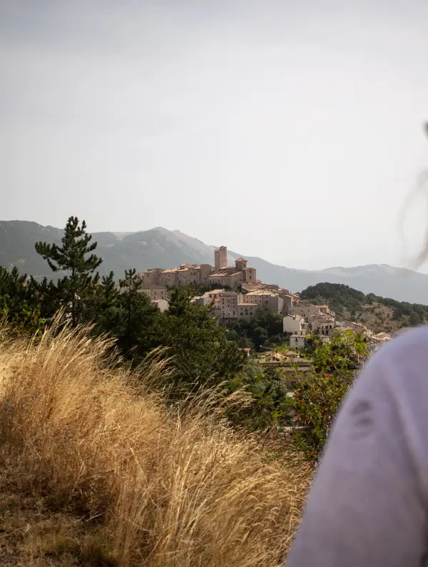 View of Castel del Monte, a medieval hilltop village surrounded by green valleys during the Abruzzo E-Bike Tour
