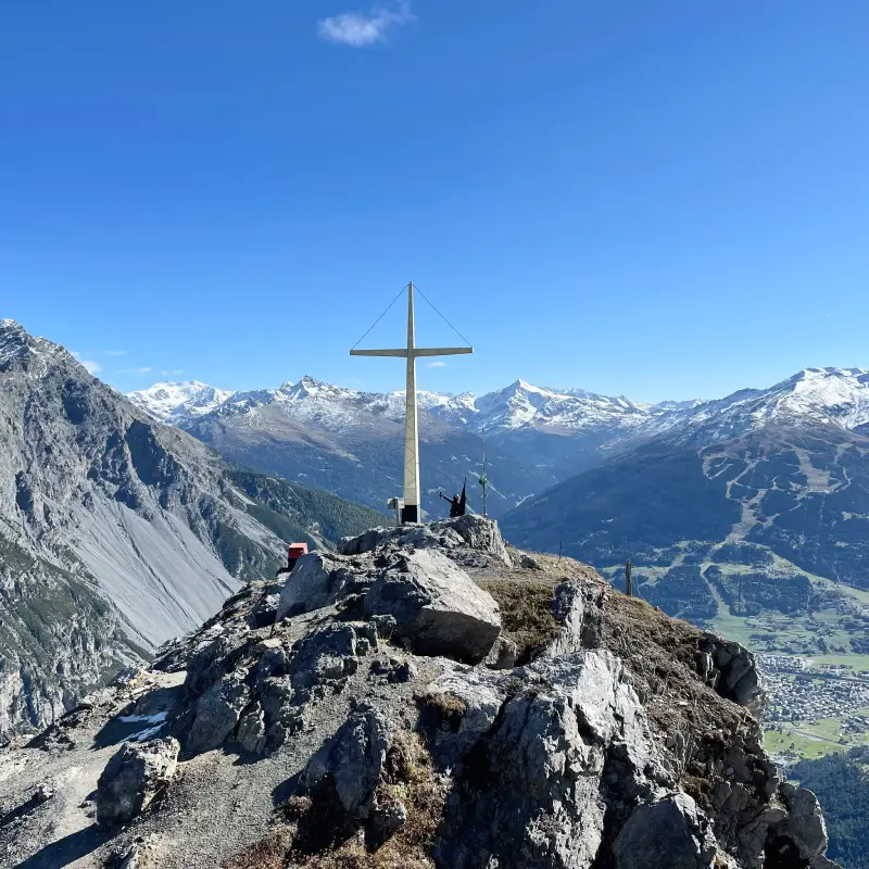 Summit cross on Monte Scale overlooking the Bormio Valley and snowy Alps