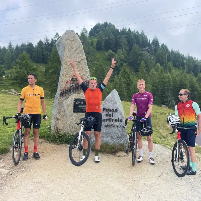 Riders celebrating at the Mortirolo Pass summit during the Stelvio to Lake Como Bike Tour