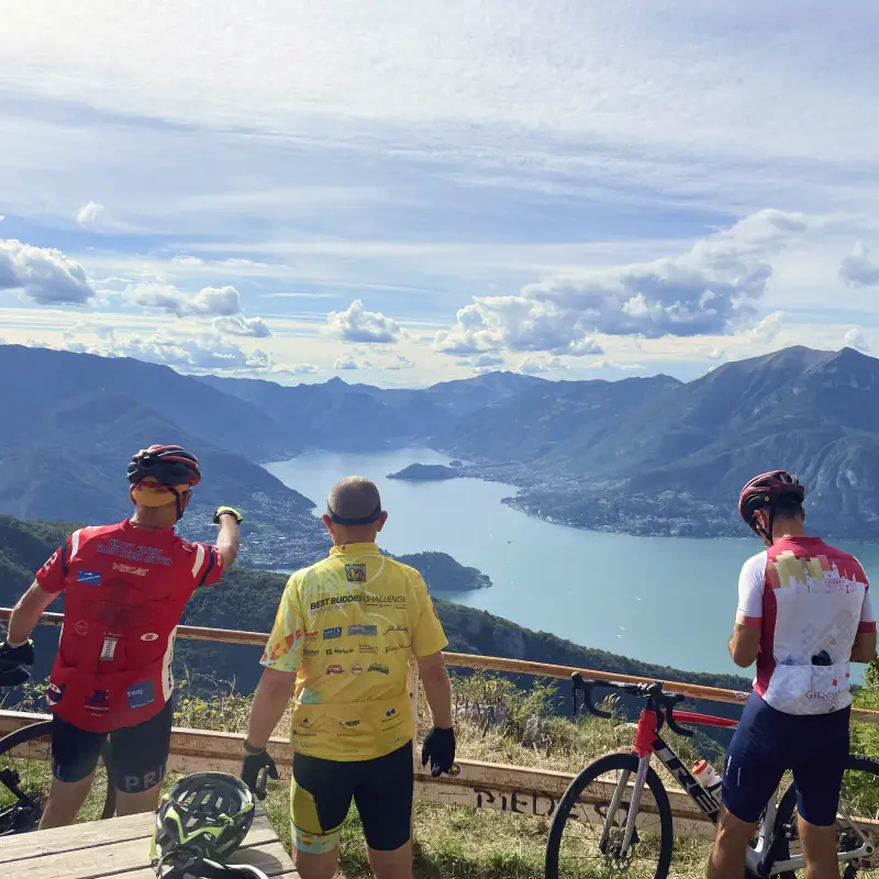 Cyclists admiring the stunning view over Lake Como from Passo Agueglio on the Stelvio to Lake Como Bike Tour
