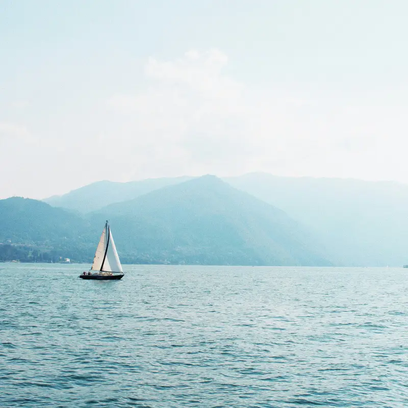 Sailboat gliding on the calm waters of Lake Como marking the end of the Stelvio to Lake Como Bike Tour