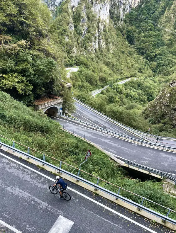 Cyclist climbing the winding tunnels of San Boldo Pass in the Veneto mountains