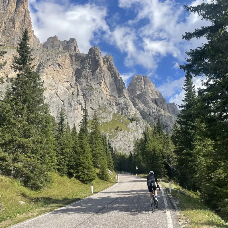 Cyclist riding through the dramatic scenery of Passo Sella in the Dolomites