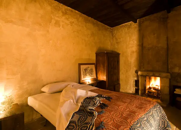 Cozy bedroom with fireplace at Sextantio Albergo Diffuso in Santo Stefano di Sessanio, Abruzzo