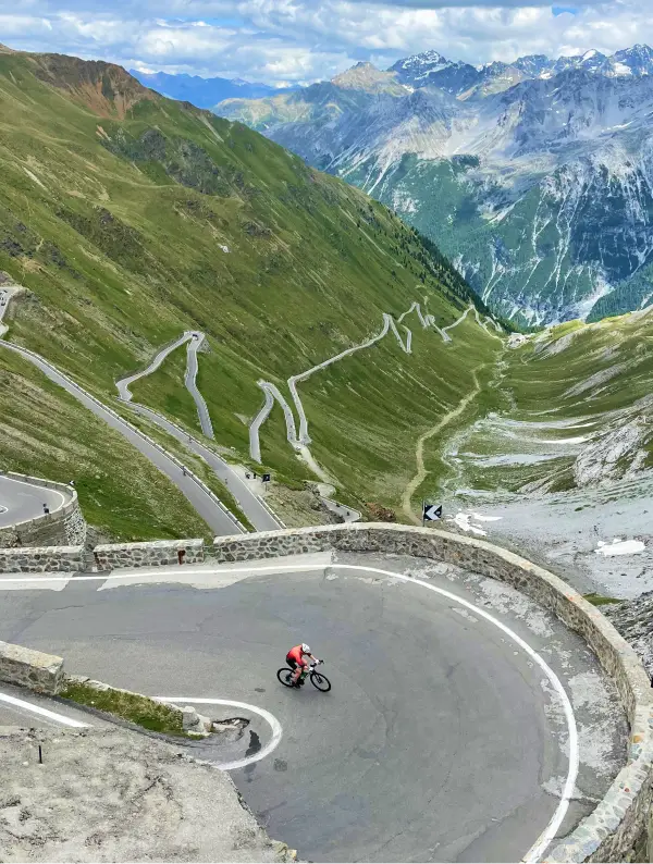 Cyclist tackling the iconic hairpins of Passo Stelvio, one of the most legendary climbs in the Alps
