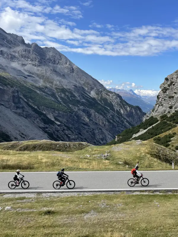 E-bikers riding up the iconic Stelvio Pass surrounded by dramatic mountain scenery