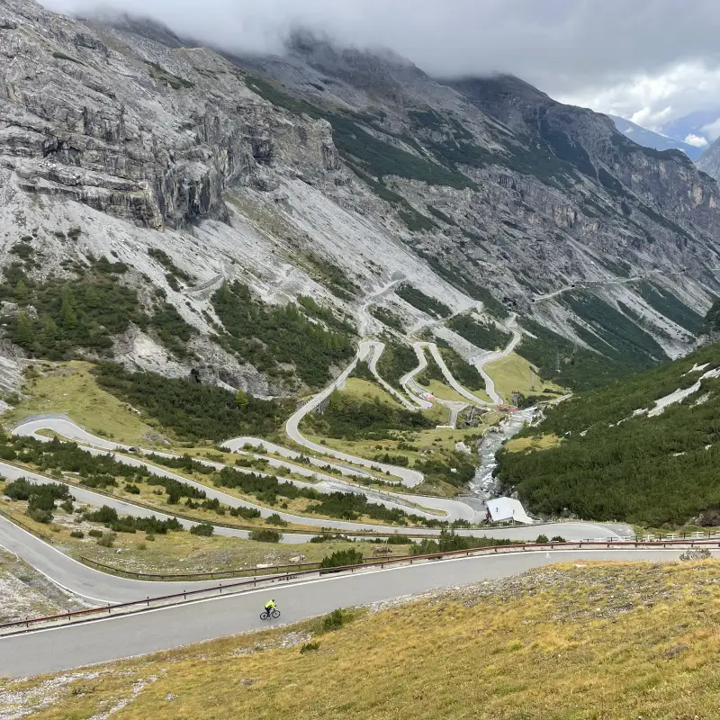 Iconic hairpin turns of the Stelvio Pass seen from above during the Stelvio to Lake Como Bike Tour