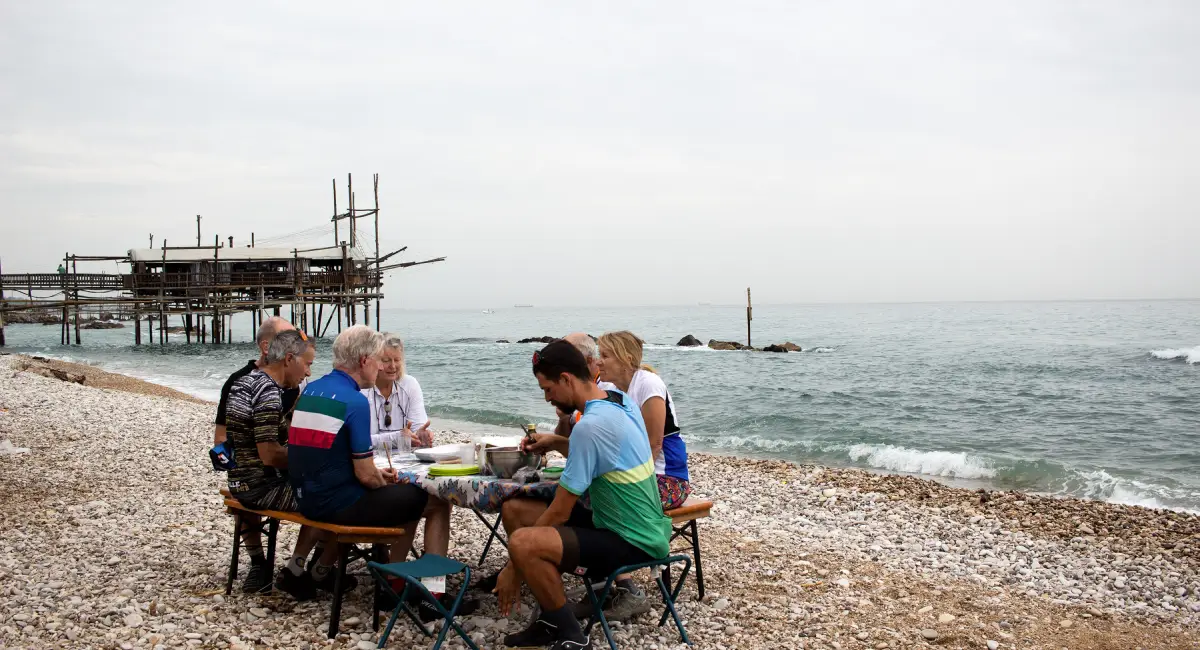 Cyclists enjoying a picnic on the beach by the Trabocchi Coast in Abruzzo