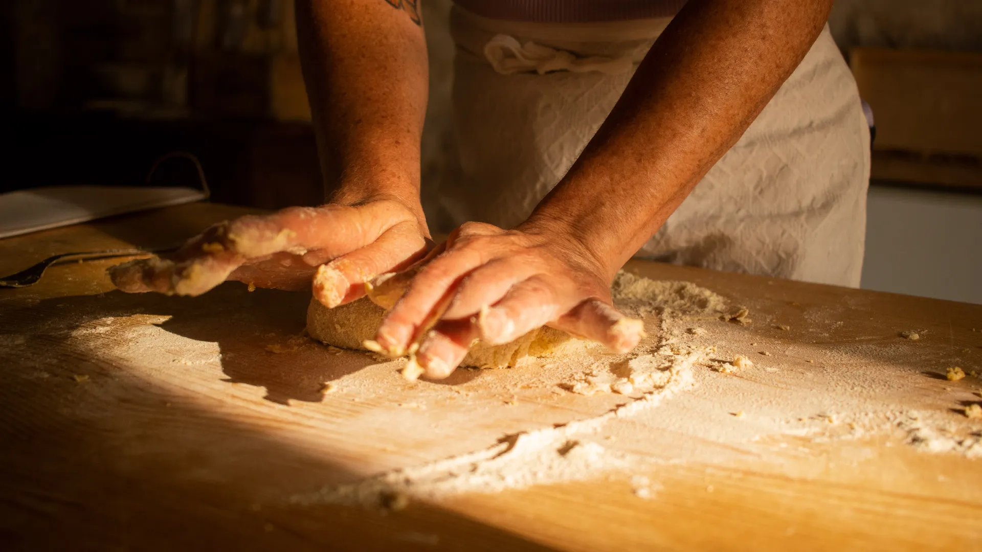 Hands kneading fresh dough during a traditional cooking class in Abruzzo, Italy