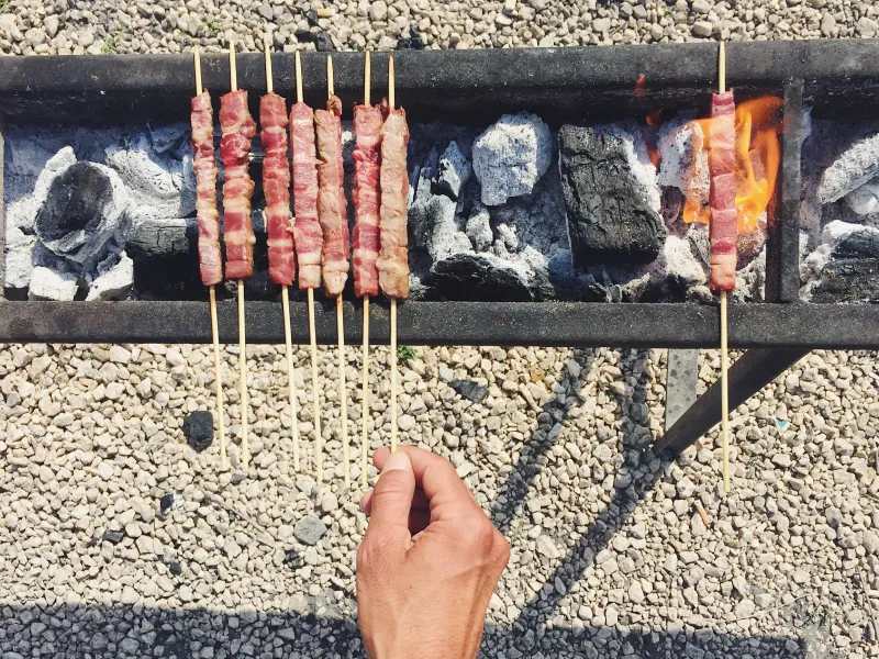 Traditional arrosticini skewers grilling over charcoal in Abruzzo