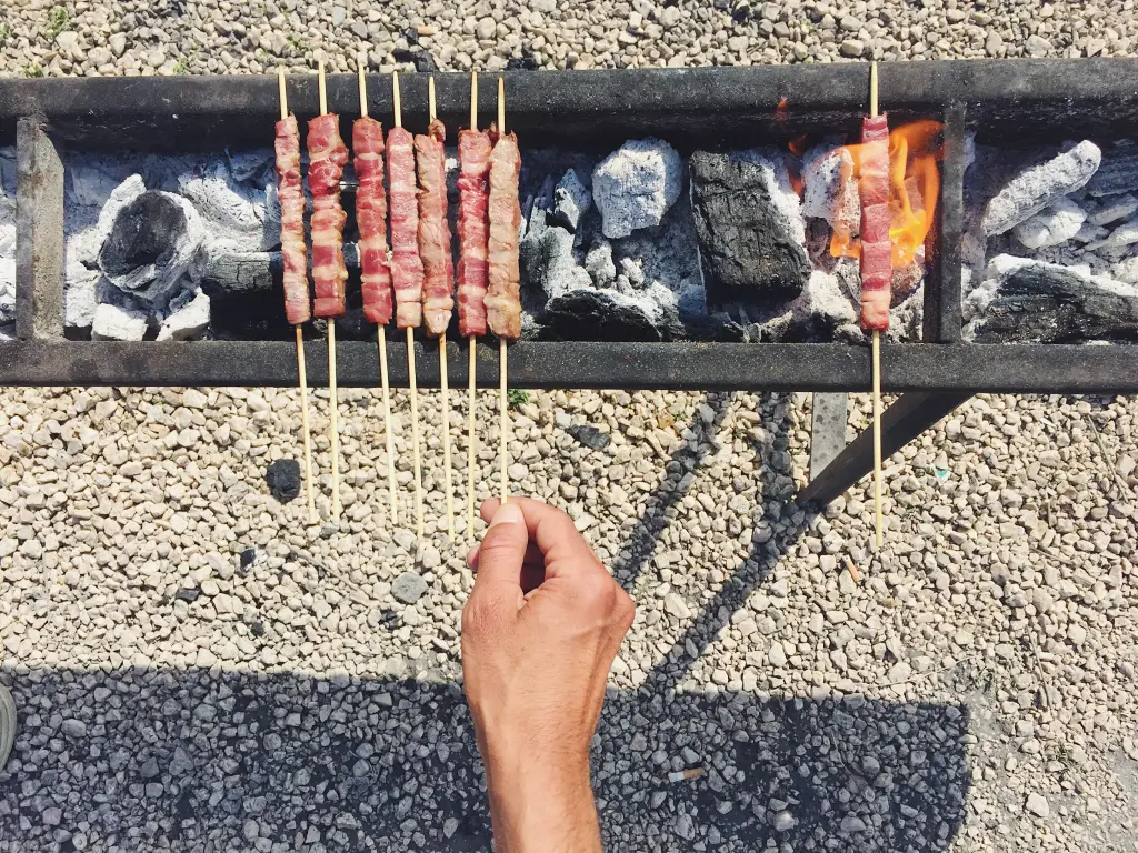 Arrosticini lamb skewers grilling over charcoal, a classic street food from Abruzzo