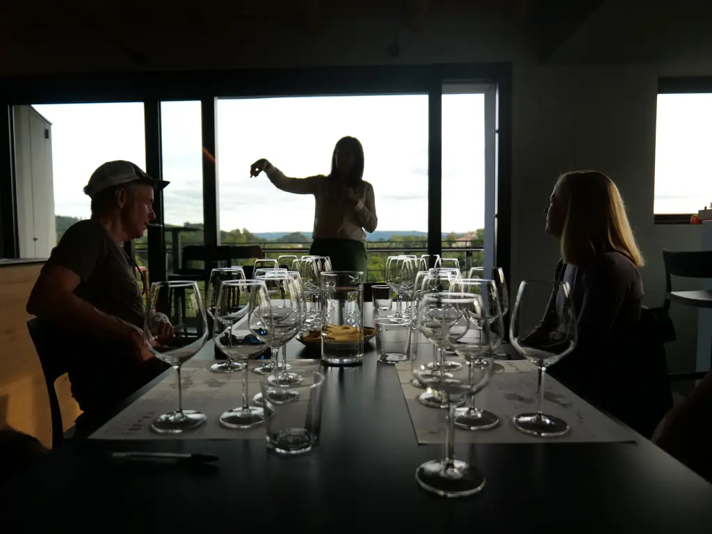 Wine tasting at Bastia winery in the Prosecco hills with glasses and bottles arranged on a table overlooking the vineyards