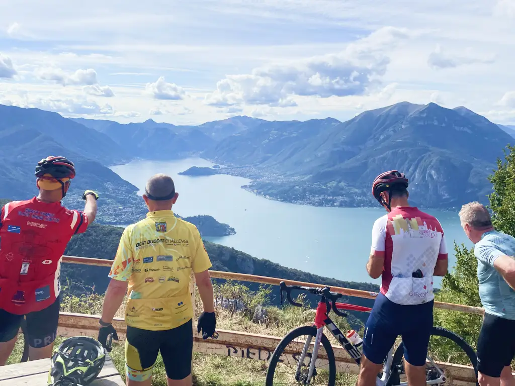 Cyclists admiring the stunning view over Lake Como from Passo Agueglio viewpoint