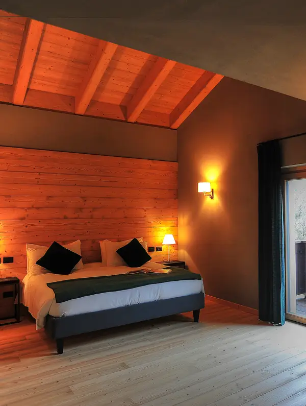 Cozy hotel room with wooden interiors and warm lights, typical mountain lodge used during the Dolomites bike tour