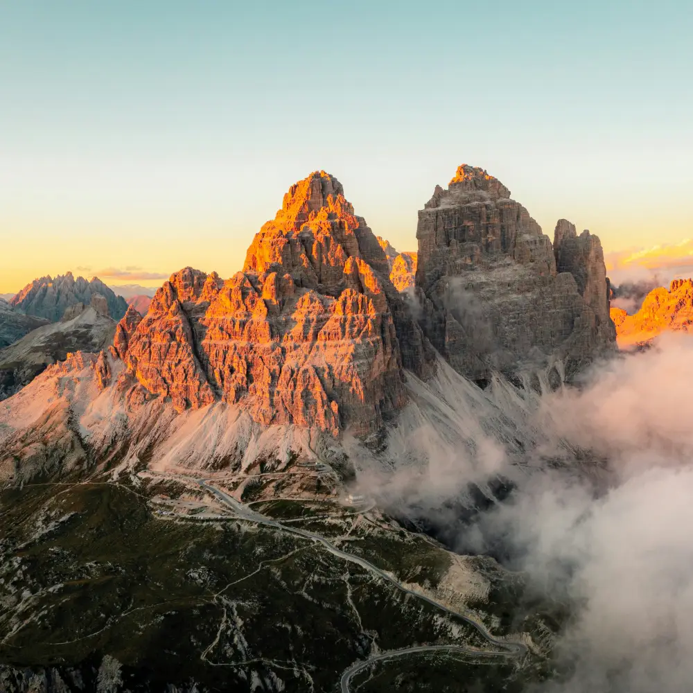Sunset light illuminating the Dolomites peaks in a warm red glow, the famous Enrosadira phenomenon seen from the Tre Cime di Lavaredo