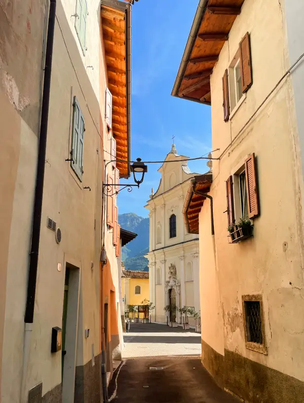 Narrow cobblestone street leading to a small church in a charming lakeside village near Lake Garda