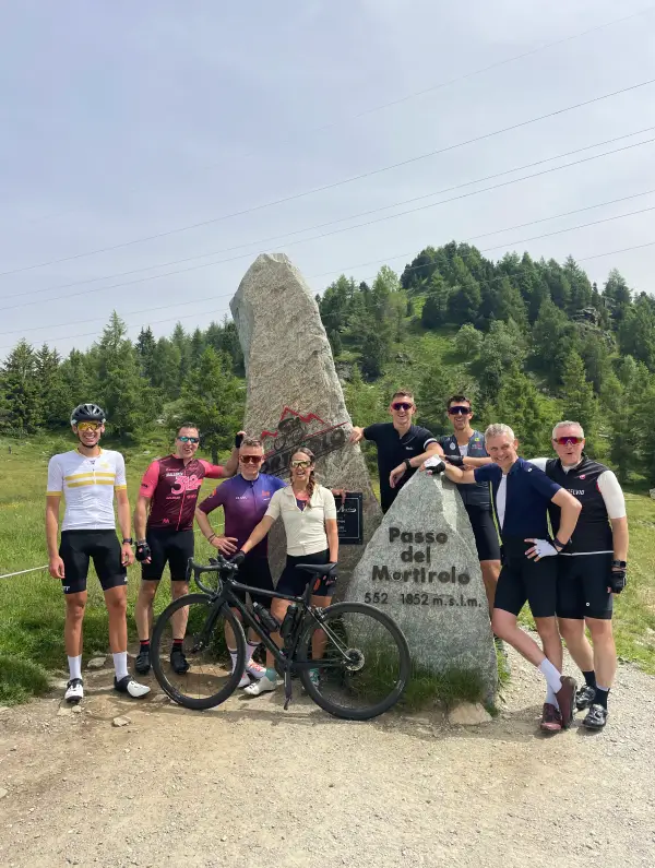 Cyclists posing at the top of Passo del Mortirolo, one of the toughest climbs in the Italian Alps