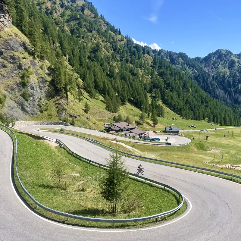 A cyclist tackling the scenic hairpins of Passo Fedaia near the Marmolada Glacier