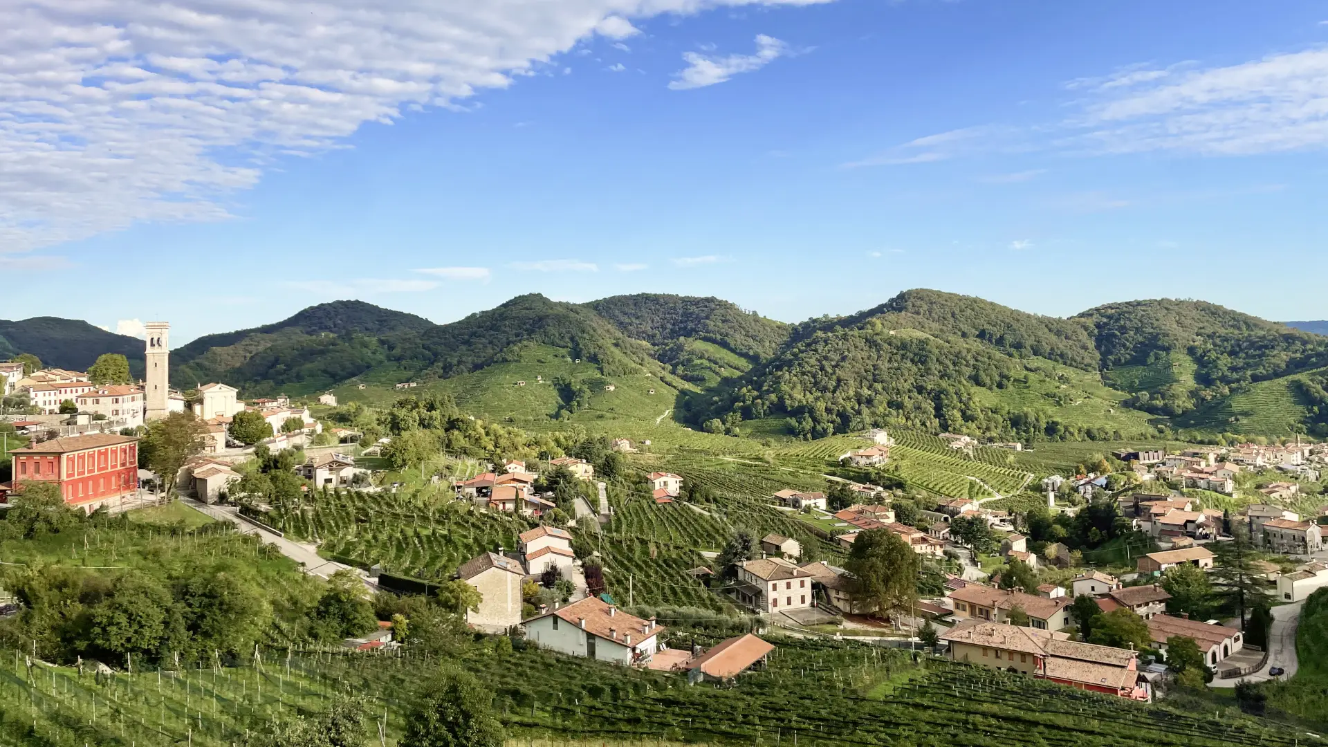 Panoramic view of the Prosecco hills near Valdobbiadene, Italy, with vineyards and small villages surrounded by rolling green hills