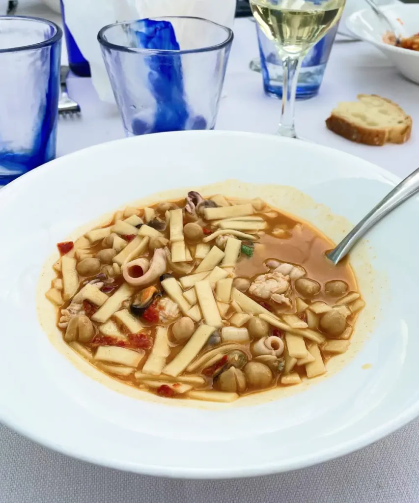 Traditional Abruzzese dish of sagne e ceci with seafood and chickpeas served with white wine