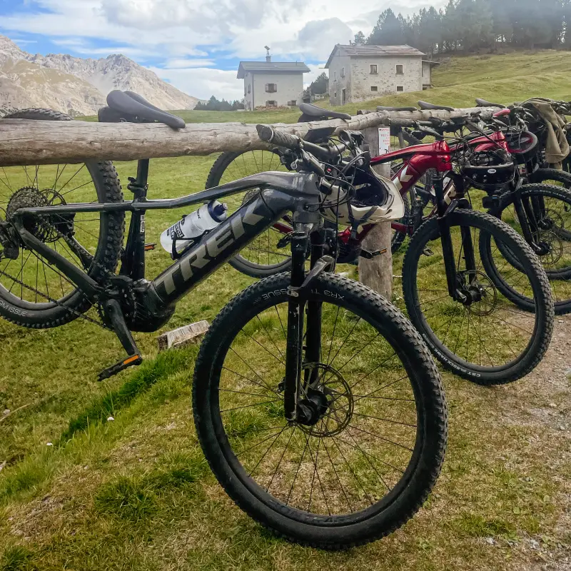 Trek e-mountain bikes parked at an alpine hut during a Vago Cycling tour in the Italian mountains