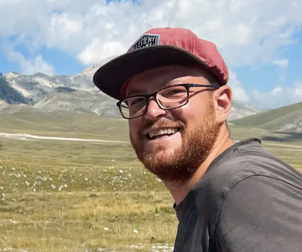 Vago Cycling team member smiling in the Italian mountains during a bike tour