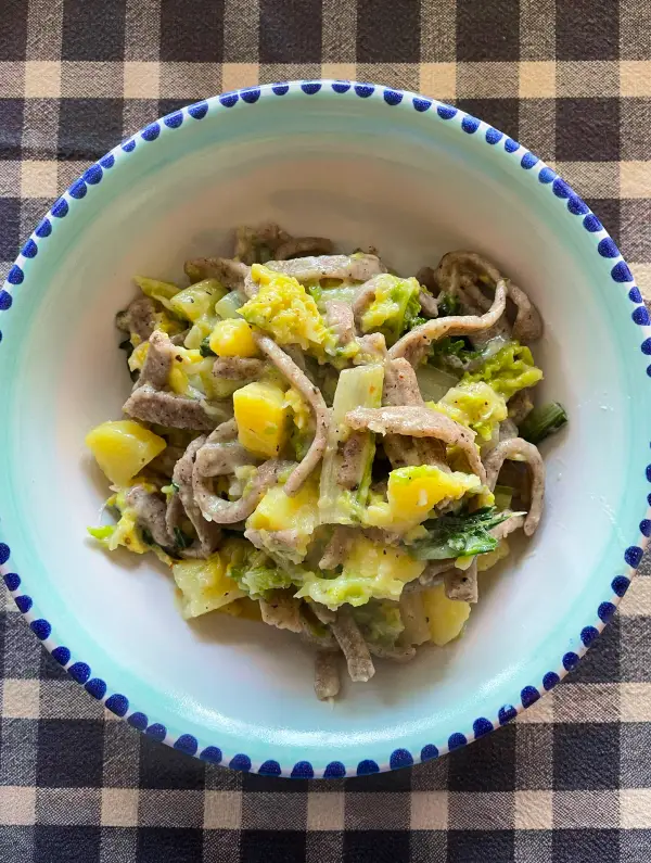 Traditional Valtellina dish of pizzoccheri pasta with potatoes, cabbage and cheese after a day of cycling